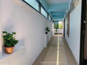 um corredor com plantas nas paredes em Bonny Hotel em Lamai