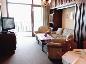 A television and/or entertainment centre at LB4 Seeblick Appartement Haus Landskron mit direktem Seezugang am Ossiachersee