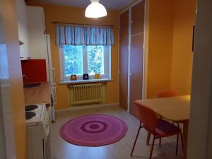 a kitchen with a table and a window and a rug at Kotamäen Wanha Koulu in Pieksämäki