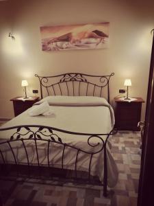 1 dormitorio con 1 cama y 2 mesitas de noche con lámparas en B&B La Dimora Di Nettuno, en Nápoles