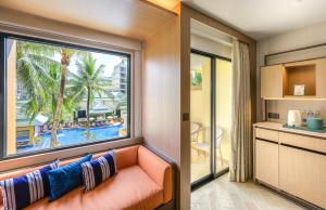 a living room with a couch and a large window at Holiday Inn Resort Phuket, an IHG Hotel - SHA Extra Plus in Patong Beach