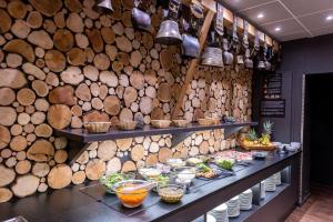 a restaurant with a bunch of wooden logs on the wall at Village Club La Lauza - Neaclub in Valmeinier