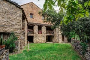 um velho edifício de pedra com um quintal em frente em Casas Rurales Molinias em Fosado