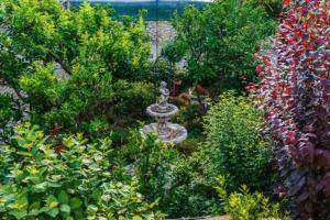 a garden with a statue in the middle of flowers at Apartments Roda in Supetar