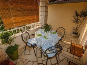 a table and chairs sitting on a patio with a window at Apartments Roda in Supetar