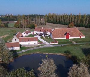 una vista aerea di una fattoria con un fienile e uno stagno di La maison des biquettes a Romorantin