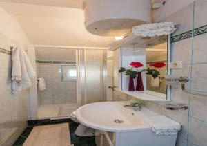 een witte badkamer met een wastafel en een douche bij Apartments Roda in Supetar