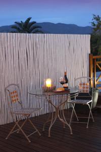 a table and chairs with a candle on a deck at The Potting Shed Guest House in Hermanus