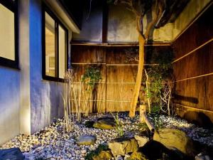 una casa con un giardino roccioso di fronte a un edificio di 柏 花小七 Haku Flowers Seven a Kyoto