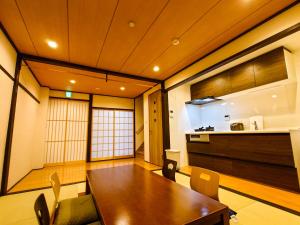 a dining room with a table and a kitchen at 柏 花小七 Haku Flowers Seven in Kyoto