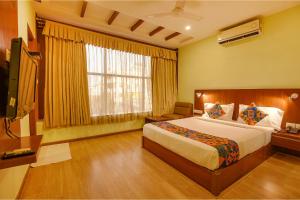 um quarto com uma cama grande e uma janela em FabHotel The BTM Palace em Bangalore