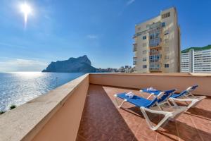 a balcony with two chairs and a view of the ocean at Villas Guzman - Apartamento Tramontana in Calpe