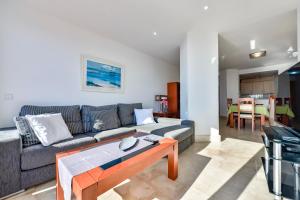 uma sala de estar com um sofá e uma mesa em Villas Guzman - Apartamento Tramontana em Calpe