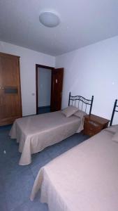 a bedroom with two beds and a dresser in it at Apartamento Islas Malvinas 39 in Vecindario