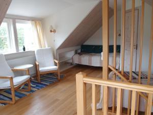 1 dormitorio con 1 cama y 2 sillas blancas en Huggehus, en Förslöv