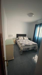 Un dormitorio con una cama y una mesa. en Apartamento Islas Malvinas 39 en Vecindario