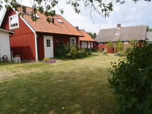 una fila de casas rojas con un patio en Huggehus, en Förslöv