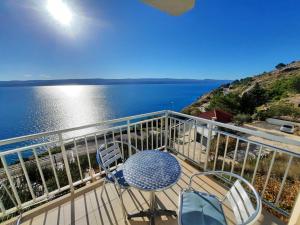 a balcony with a table and chairs and a view of the water at Apartments Rose in Lokva Rogoznica