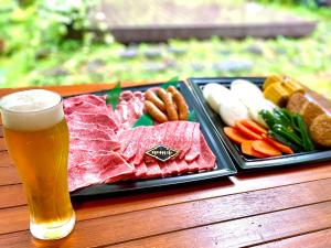 a tray of meat and vegetables and a glass of beer at Garden Villa in Fujiyoshida