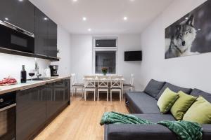 a kitchen and living room with a couch and a table at Apartamenty Zakopane Krupówki in Zakopane
