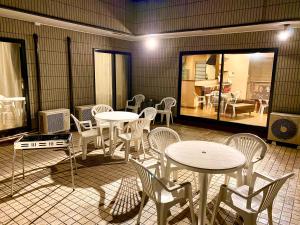 uma sala com mesas e cadeiras e uma sala de jantar em Garden Villa em Fujiyoshida