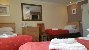 a hotel room with two beds and a mirror at Westholme Hotel in Blackpool