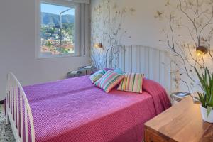 - une chambre avec un lit doté de draps violets et une fenêtre dans l'établissement ALIDA House Top Floor, à Levanto