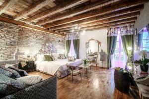 - une chambre avec un lit et un mur en briques dans l'établissement Vitrum - Como Luxury Suites, à Côme