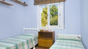 カレリャ・デ・パラフルジェリにあるRoc 1D - Calella de Palafrugellのベッドルーム1室(ベッド2台、窓付)