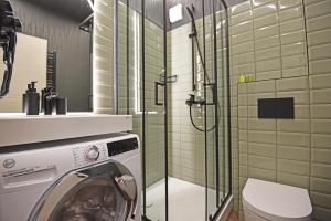 a washing machine in a bathroom with a shower at Čiki Puki Purslai in Palanga
