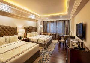 a hotel room with two beds and a television at The Indus Valley in Leh