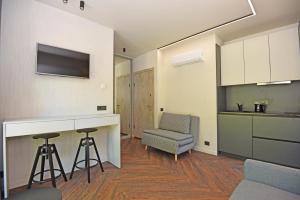 a kitchen and living room with a counter and a chair at Čiki Puki Purslai in Palanga