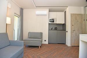 a living room with a couch and a chair and a kitchen at Čiki Puki Purslai in Palanga +10 photos