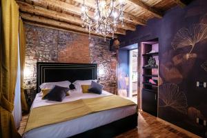 ein Schlafzimmer mit einem großen Bett und einem Kronleuchter in der Unterkunft Vitrum - Como Luxury Suites in Como