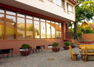 ein Backsteingebäude mit Fenstern, Tischen und Stühlen in der Unterkunft Aismares Hostel in Klaipėda