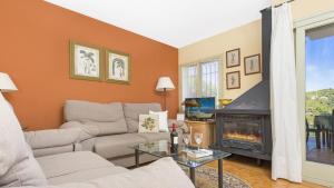 un soggiorno con divano e camino di 1 Rond - Llafranc a Santa Margarita