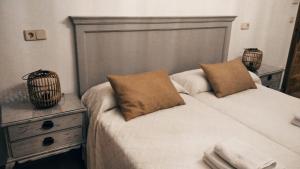1 dormitorio con 1 cama con 2 almohadas en Casa La Plazuelilla, en Chinchón