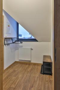 an attic room with a window and a wooden floor at Apartmány Na handě in Boží Dar