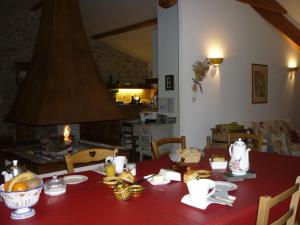 une table à manger avec un tissu de table rouge dans l'établissement Chambre d'Hôtes La Bourdasse, à Loubens