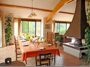 a large dining room with a long table and a stove at Chambre d'Hôtes La Bourdasse in Loubens