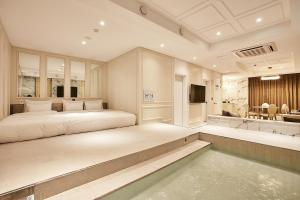 仁川市Hotel Wanted的一间带大床的卧室和一个游泳池