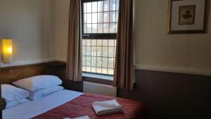 a hotel room with a bed and a window at Westholme Hotel in Blackpool