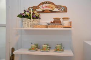 a shelf with two cups and flowers on it at Aegli Rooms in Tinos