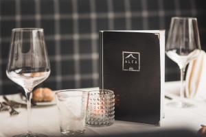 uma mesa com dois copos de vinho e uma caixa em ALFA hotel em Serfaus