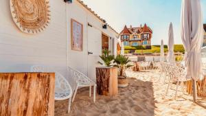 a group of chairs and umbrellas on a beach at relax @the beach in De Haan