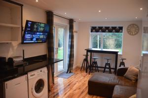 a living room with a couch and a table in a room at The Annexe @ Woodland in Bury