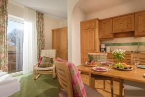 a kitchen and dining room with a table and chairs at Aurora Appartements inklusive freiem Thermeneintritt in Bad Hofgastein