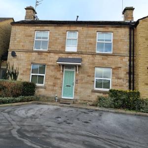 a brick house with a green door on a street at Apartment 11, Mirfield, West Yorkshire in Mirfield
