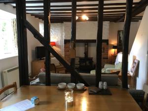 a room with a table and a living room at 200 year old Gardener's cottage, Mid Wales in Llanidloes
