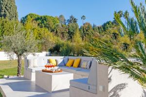 a patio with a blue couch with yellow pillows at Villa SOHA Bed & Breakfast in Mougins
